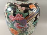 a vase with a bird on it sitting on a table