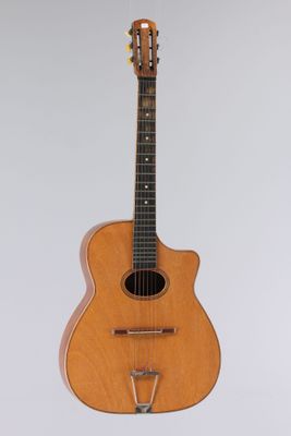 an acoustic guitar hanging on a wall with a white background