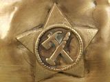 a gold vase with a hammer and a star on it
