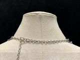 a white mannequin with a silver chain on it
