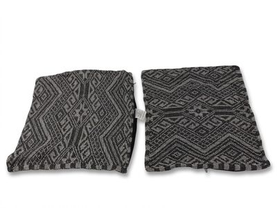 une paire de coussins à motifs noirs et blancs sur fond blanc