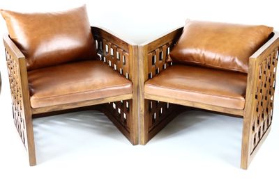 deux fauteuils en cuir marron placés l'un à côté de l'autre