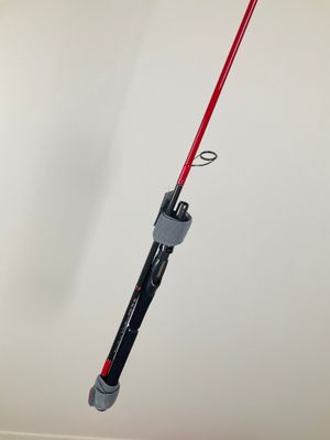 a close up of a red and black fishing rod on a white wall