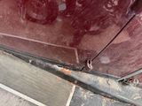 a close up of a car door with rust on it