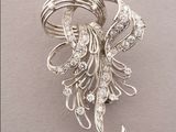 an image of a brooch of silver and diamonds on a white background