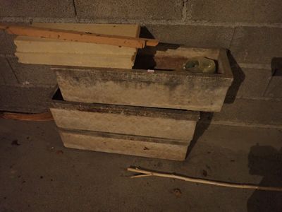 un tas de bois posé par terre près d'un mur de briques
