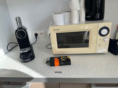 un micro-ondes et une cafetière posés sur le plan de travail de la cuisine