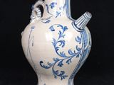 a blue and white vase with a handle on a black background