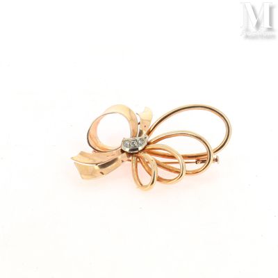 an image of a gold bow brooch with a diamond in the center