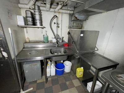 a kitchen with a sink, stove, and other items in it
