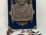 a metal box with various items in it on a white surface