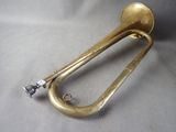 an old brass trumpet sitting on top of a white cloth
