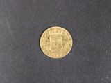 a close up of a gold coin on a black surface