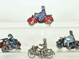 four miniature figurines of people riding motorcycles on display