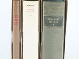 trois livres sont empilés sur une surface blanche
