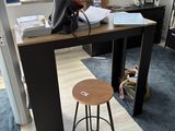 a desk with a stool and a computer on it