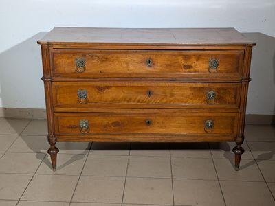 une commode en bois dans une pièce au sol carrelé