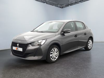 La voiture grise est garée dans une grande pièce au sol noir.