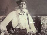 an old photo of a man sitting on a couch with a hat on