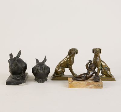 trois figurines en bronze représentant des chiens et un chat, posées sur un socle en marbre
