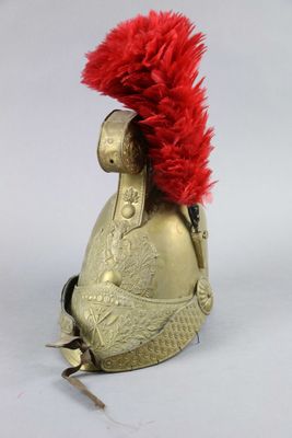a gold helmet with a red feather on it