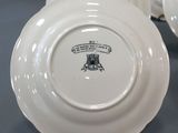 several white plates with black designs on them are on a table
