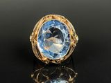 a gold ring with a blue topaz stone in the center