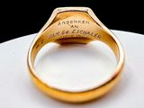 a gold ring with a sign on it on a white plate
