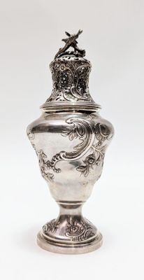 une image représentant un vase en argent surmonté d'un oiseau