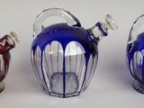 trois vases en verre de couleurs différentes posés sur une table
