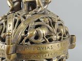 an antique bronze figurine of a globe with people on it