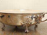 a silver bowl on a table with a handle on it