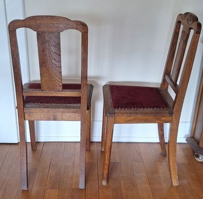 deux chaises en bois assises l'une à côté de l'autre sur un sol en bois dur