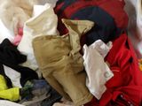 a pile of clothes on a bed in a room