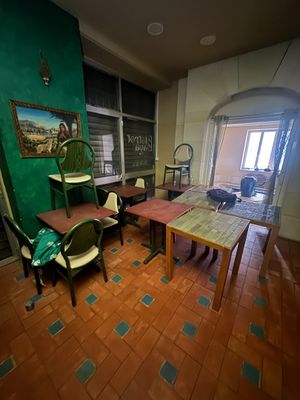 une pièce avec une table, des chaises et un tableau accroché au mur