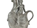 a silver vase with a statue of a woman and a child on it