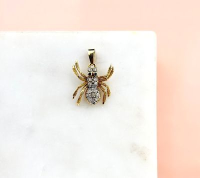 a close up of a spider pendant on a marble surface