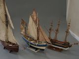 three model ships that are on display on a table