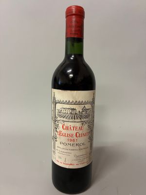une vieille bouteille de vin rouge posée sur une table blanche