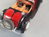 a red and black toy car on a white surface