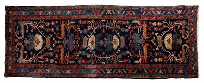 un tapis persan ancien orné d'un motif bleu et rouge sur fond blanc