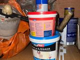 a bucket of paint and other items on a shelf