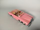 a pink toy car with a teddy bear in it