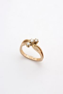 a close up of a gold ring with two diamonds on it