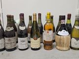 bottles of wine are lined up on a counter in front of a refrigerator