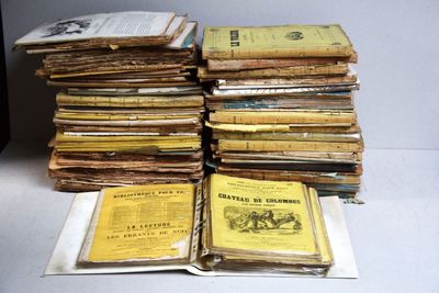 une pile de livres posée sur une table à côté d'une autre pile de livres