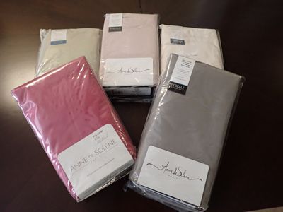 quatre feuilles roses, blanches et grises, pliées sur une table