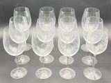 six empty wine glasses are lined up on a table