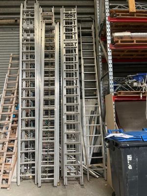 de nombreuses échelles métalliques empilées dans un local de stockage