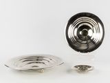une assiette en argent et une assiette en argent posées sur une surface blanche